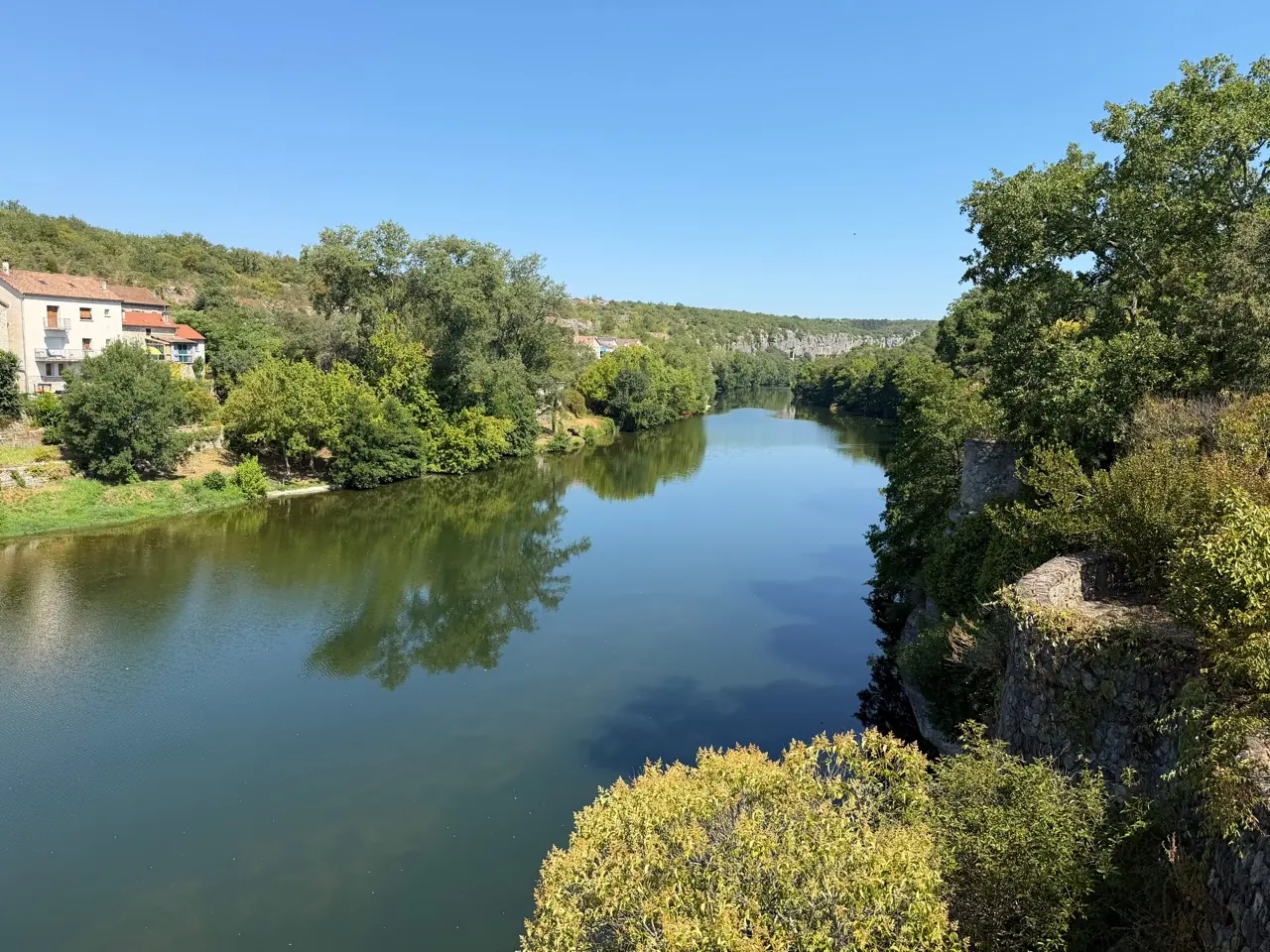 La rivière entre les arbres et les maisons de pierre